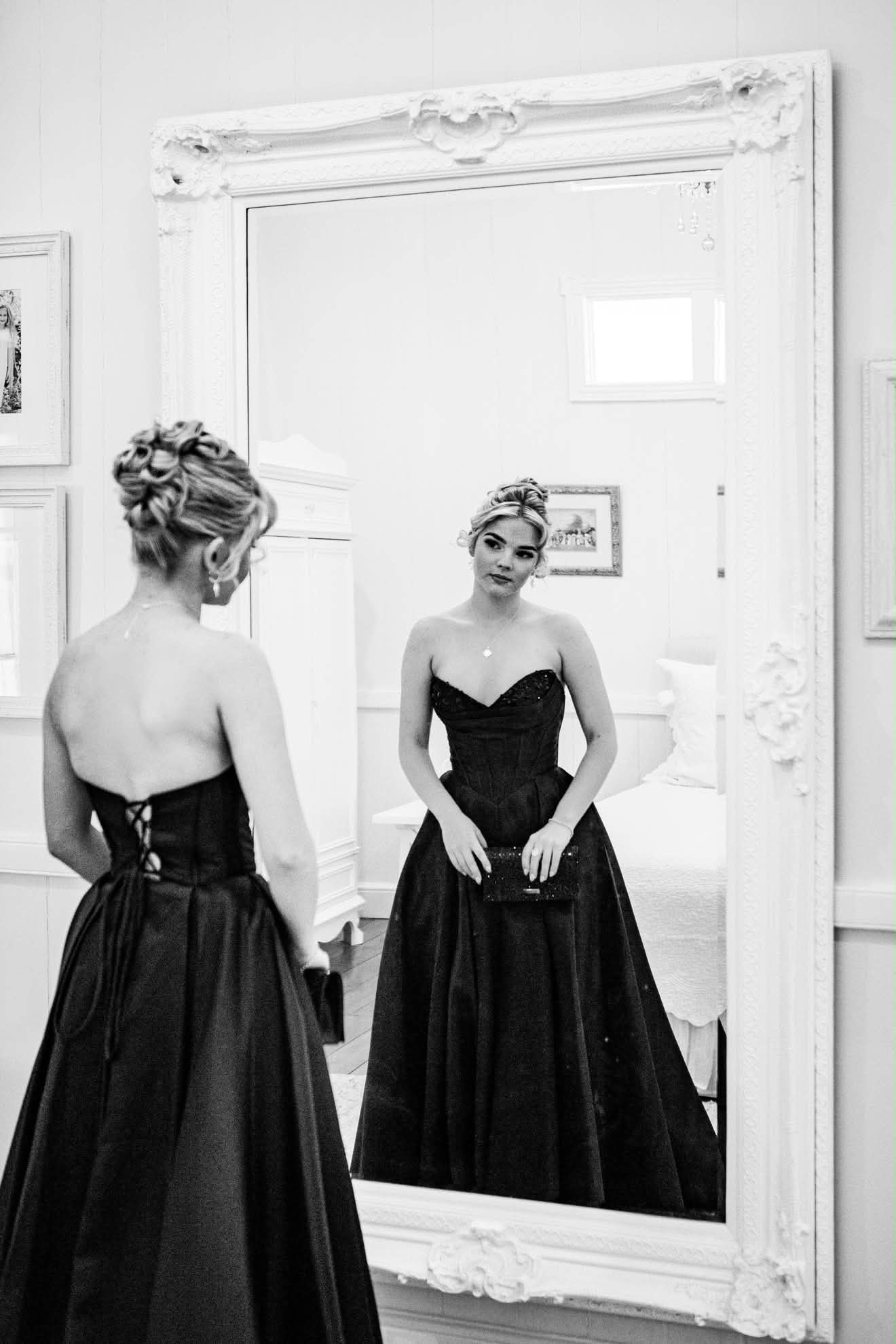 Formal upstyle and black gown reflected in a mirror